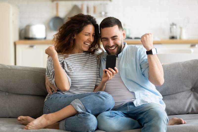 A couple celebrates making a successful offer on a house.