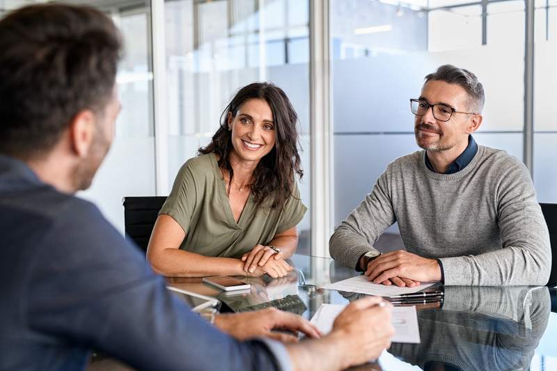 Agent meets with couple to discuss home purchase and sale agreement.