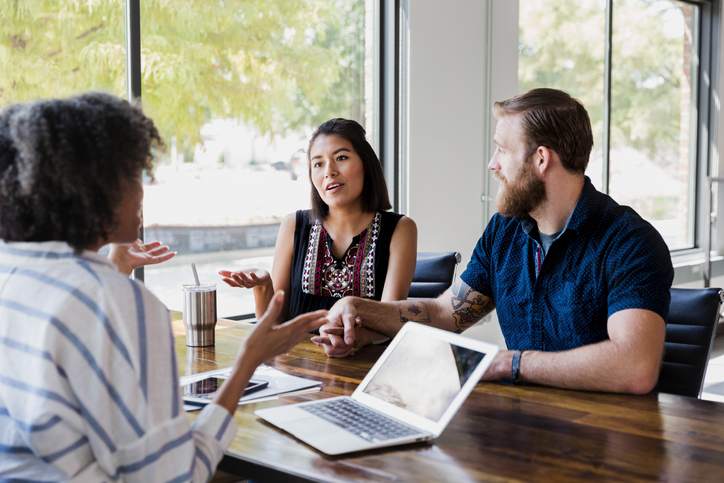 A young couple talking to their mortgage lender.