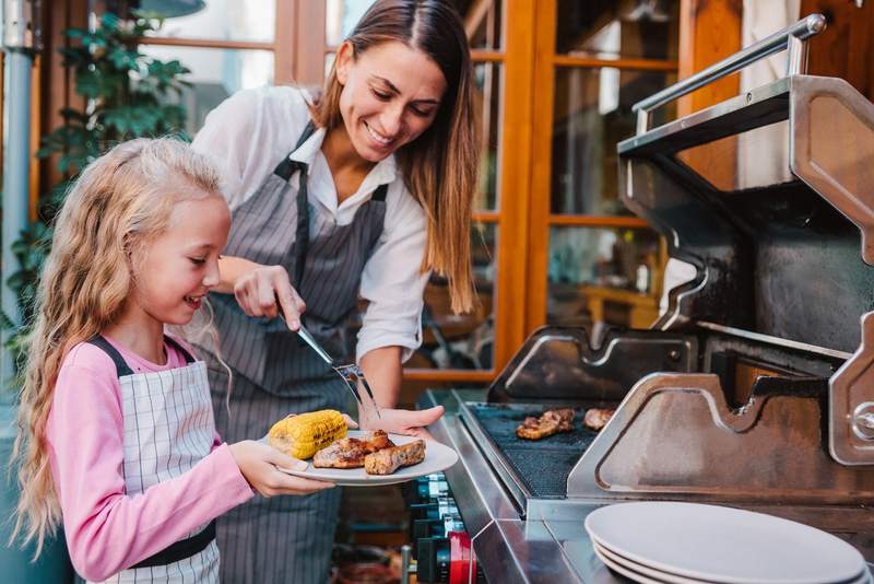 Mother and daughter having a family barbecue covered by the liability portion of their homeowners insurance.