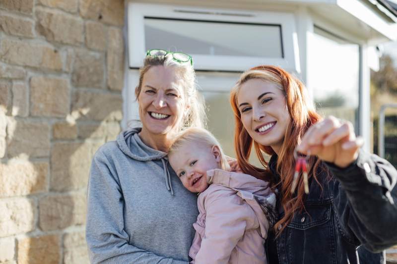 A family shows off the keys to their new home.