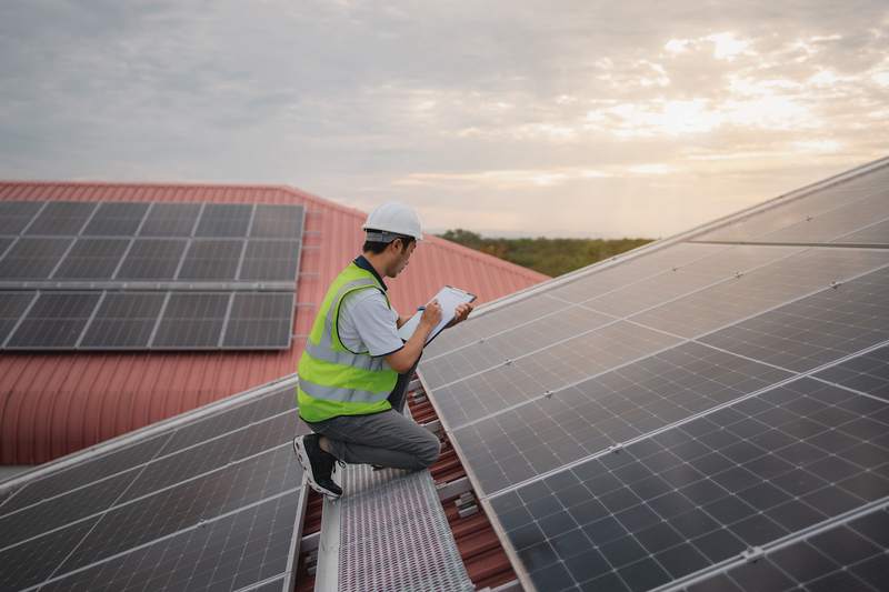 Installer checks rooftop solar panels.