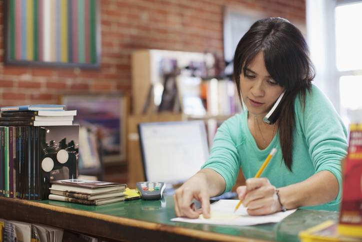 Woman checks off refinancing documents.