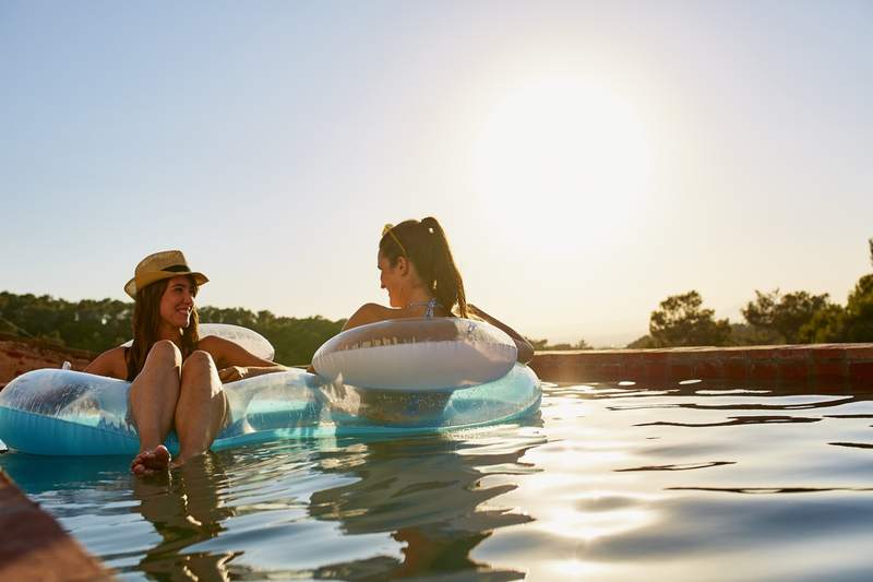 Two women in a swimming pool at home during the summer